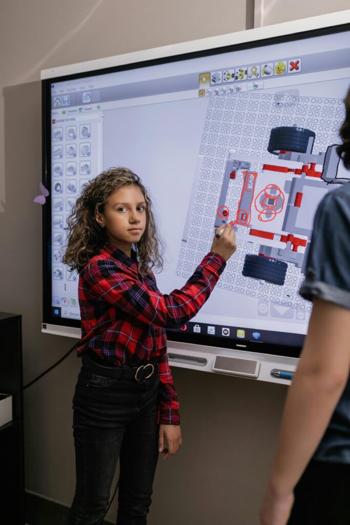 Girl using interactive board in a classroom exploring educational content.